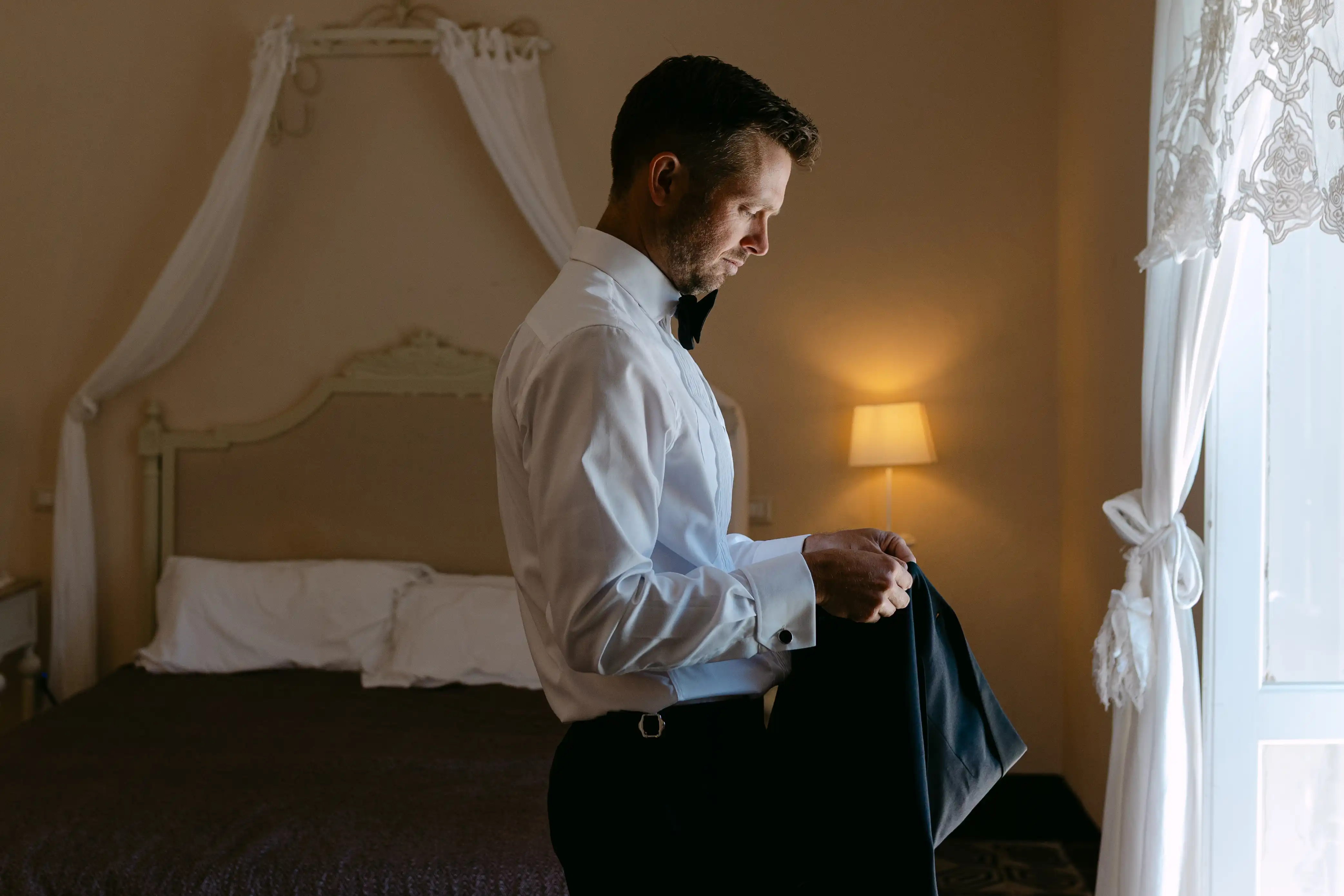 Groom getting ready in an elegant Italian villa before a luxury destination wedding in Sicily
